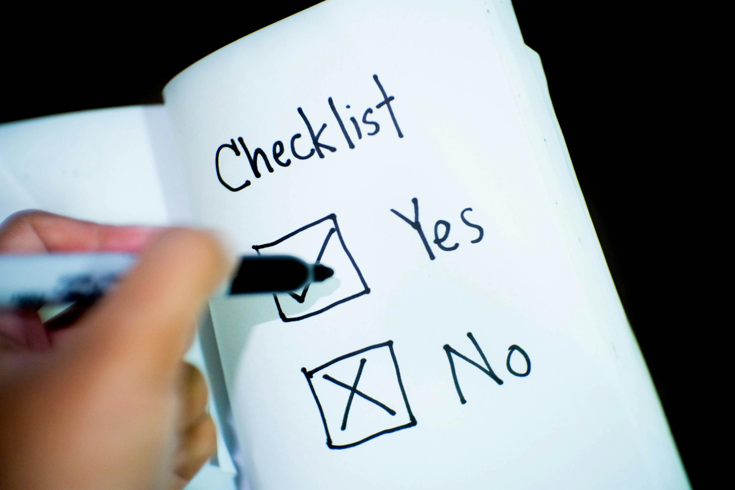 Hand checking “Yes” on a simple checklist – concept image for evaluating if your church insurance is enough