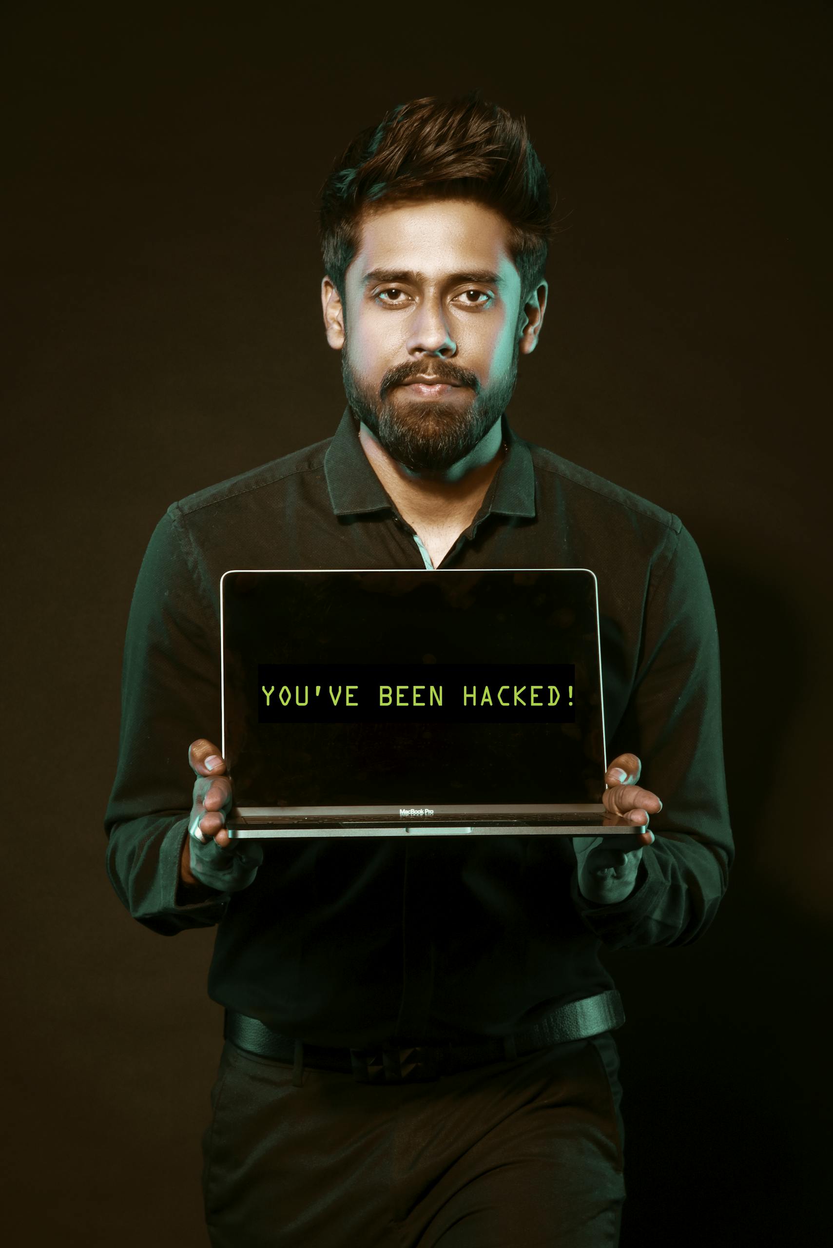 Man holding a laptop displaying "You've Been Hacked!" — representing the real risks of cybersecurity in the nonprofit world and the importance of prevention.