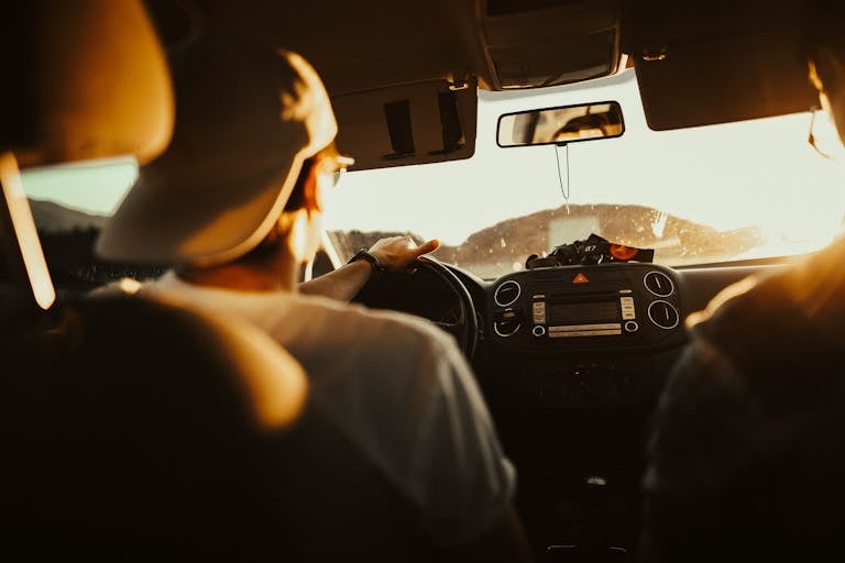 Volunteer driver on the road at sunset, representing the importance of a nonprofit driver safety program to reduce risk and ensure proper coverage.