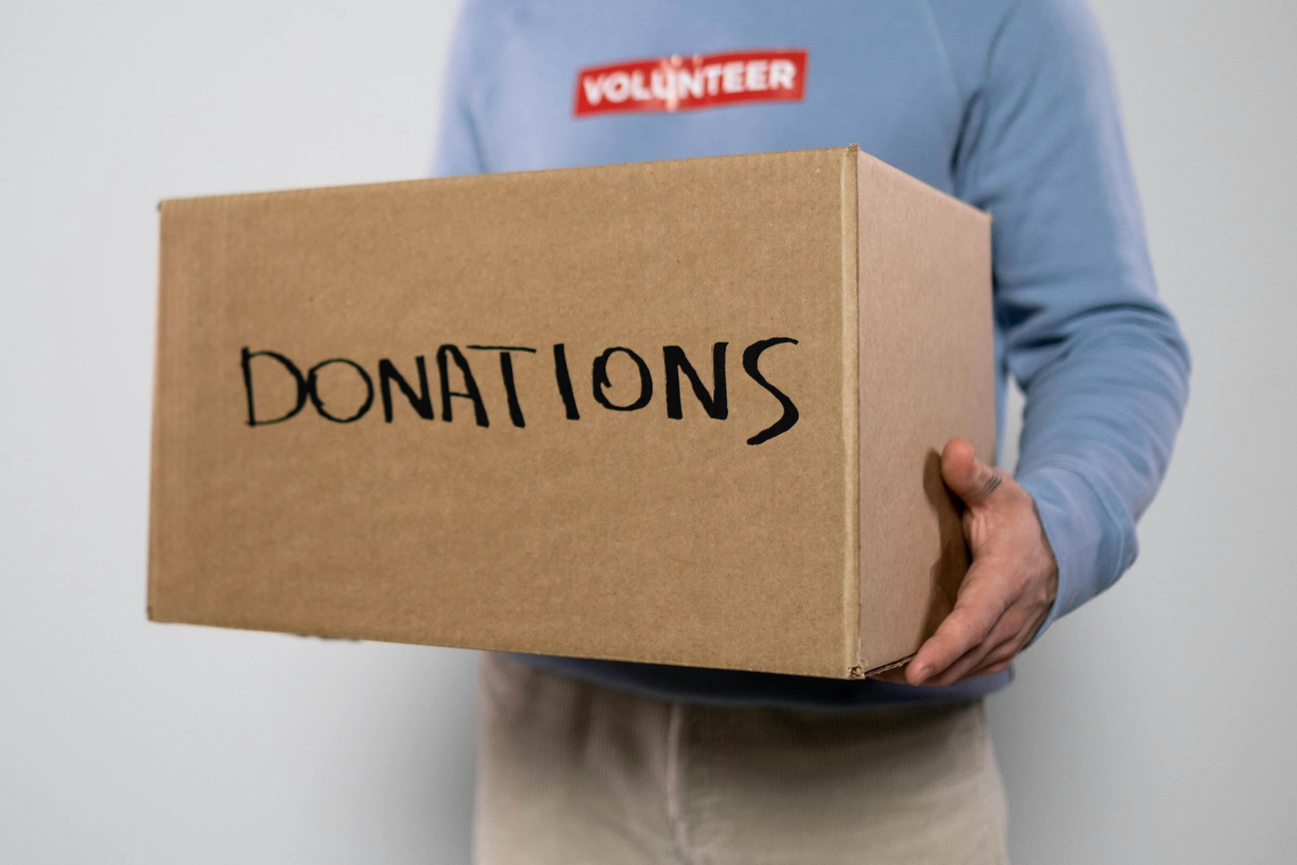 Volunteer holding a donation box—illustrating real-world activities protected by nonprofit insurance coverage.